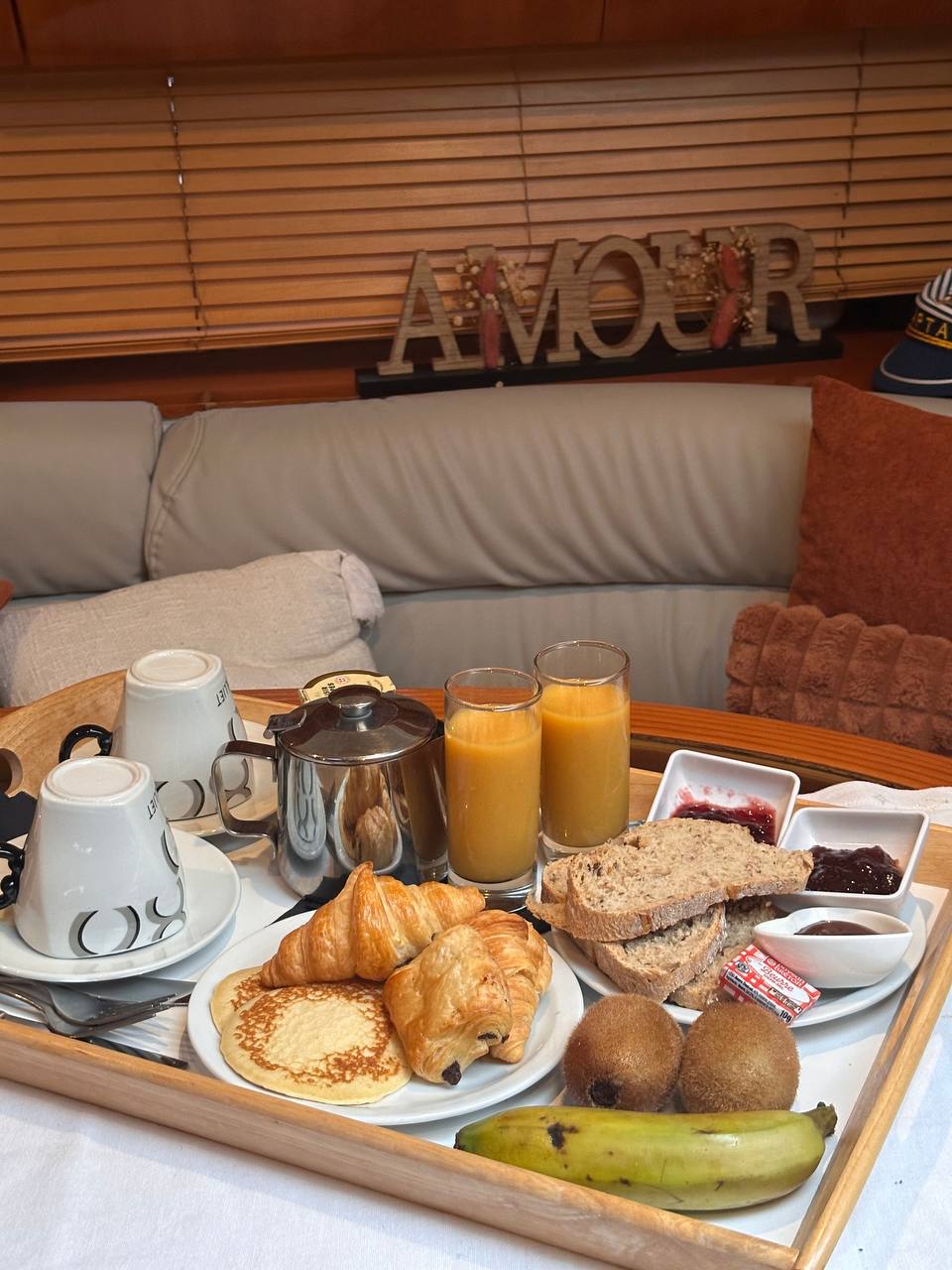Petit-déjeuner sur plateau : viennoiseries, jus de fruits et confitures
